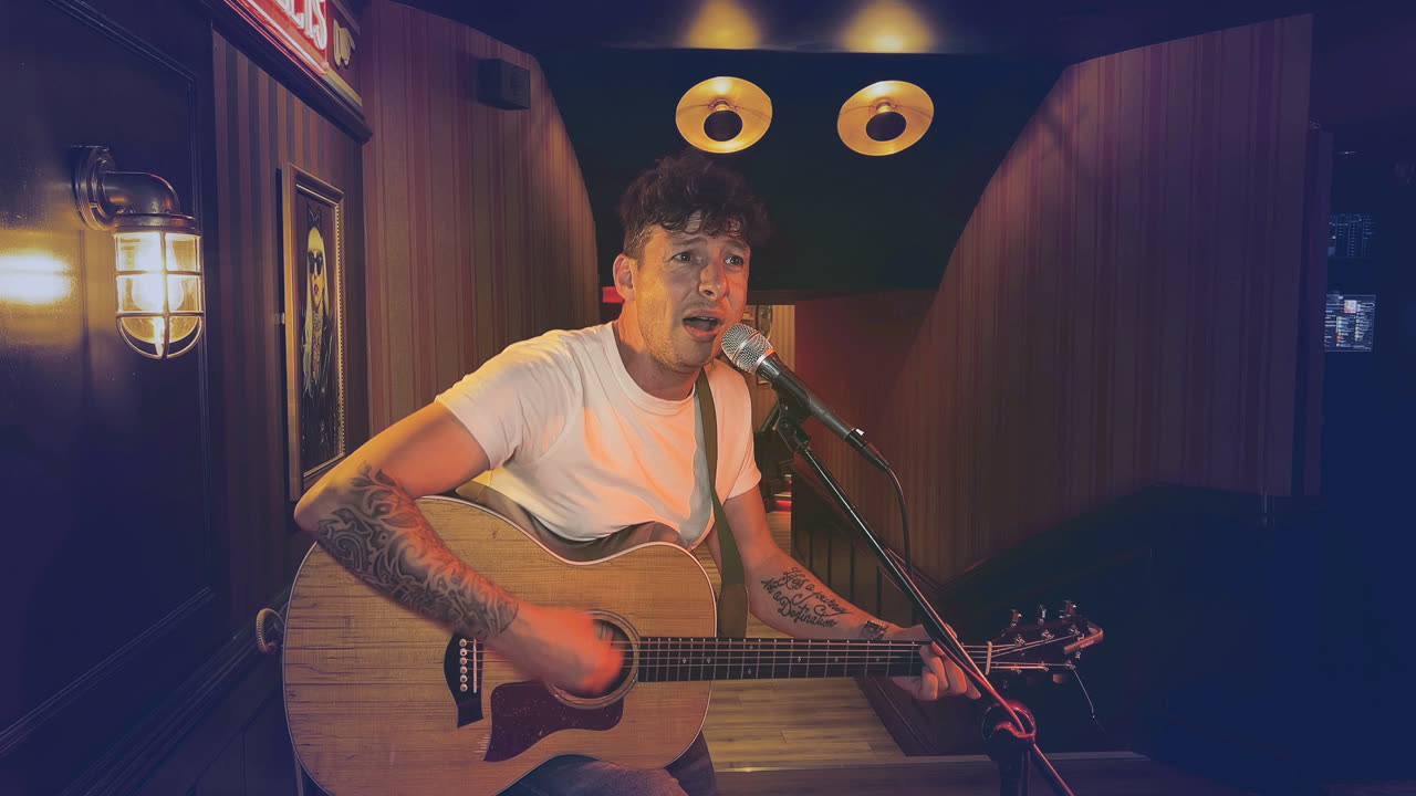 The same pub frame on the cinematic look — teal shadows against the singer's warm skin